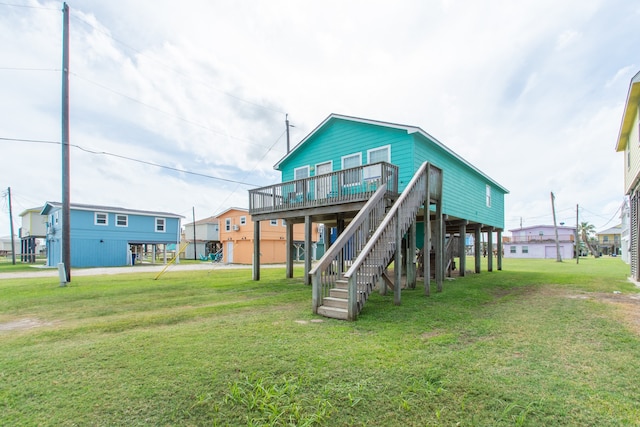 rear view of house featuring a deck and a lawn