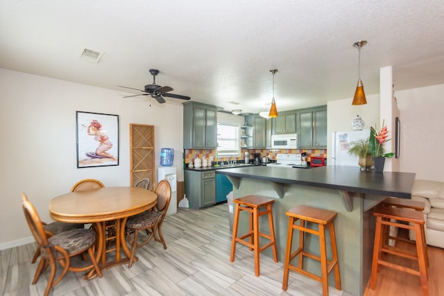 dining area with a textured ceiling and ceiling fan