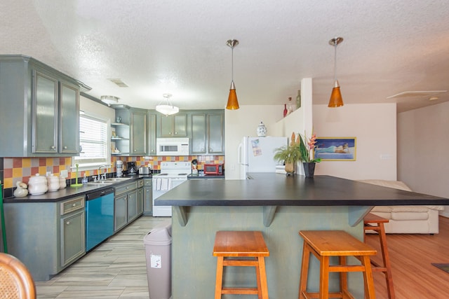 kitchen with backsplash, a textured ceiling, light wood-type flooring, a kitchen bar, and white appliances