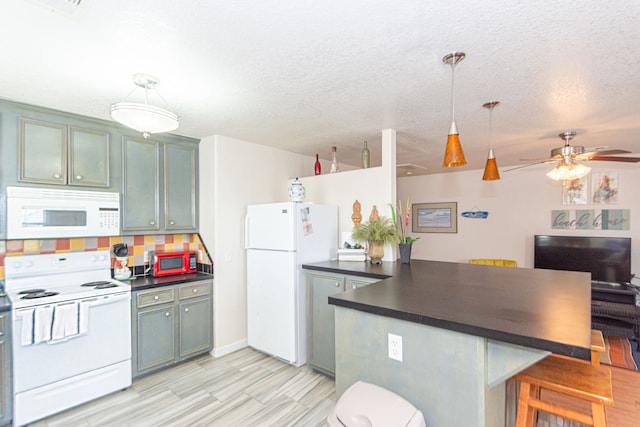 kitchen with kitchen peninsula, decorative backsplash, hanging light fixtures, a breakfast bar area, and white appliances