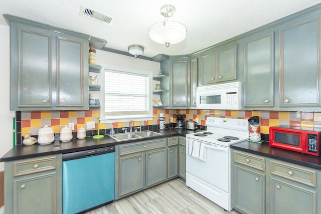 kitchen featuring white appliances, tasteful backsplash, and sink