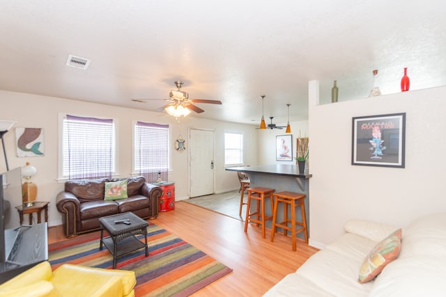 living room featuring light hardwood / wood-style flooring and ceiling fan