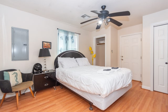 bedroom featuring light hardwood / wood-style flooring, electric panel, and ceiling fan