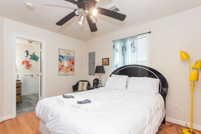 bedroom with ceiling fan, hardwood / wood-style flooring, and electric panel