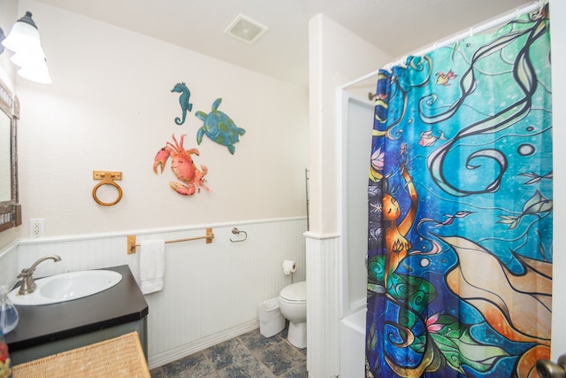 full bathroom featuring toilet, shower / tub combo, vanity, and wooden walls