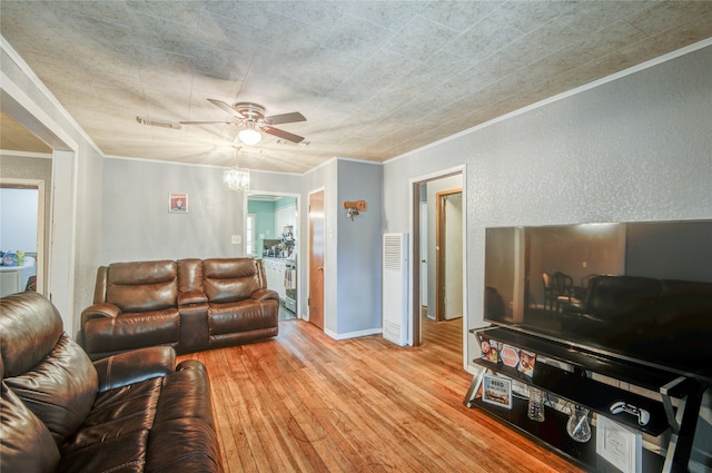 living room featuring light hardwood / wood-style floors, crown molding, and ceiling fan