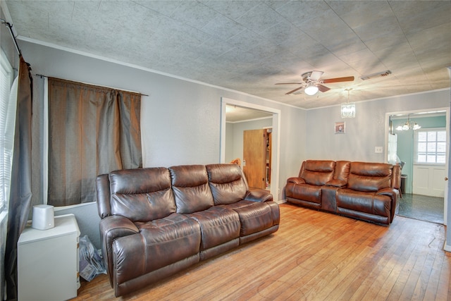 living room with ornamental molding, light hardwood / wood-style flooring, and ceiling fan with notable chandelier