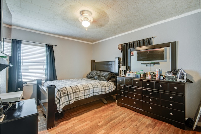 bedroom with crown molding, light wood-type flooring, and ceiling fan