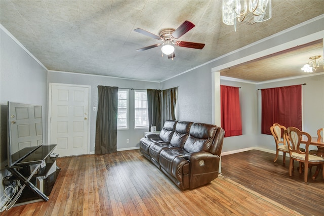 living room featuring ornamental molding, wood-type flooring, and ceiling fan with notable chandelier