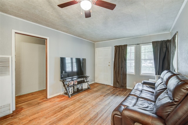 living room with light hardwood / wood-style flooring, crown molding, and ceiling fan