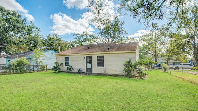 rear view of house featuring a lawn