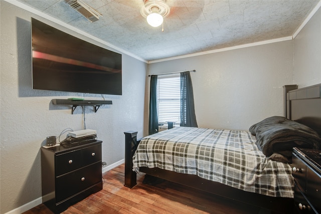 bedroom featuring ornamental molding, hardwood / wood-style flooring, and ceiling fan