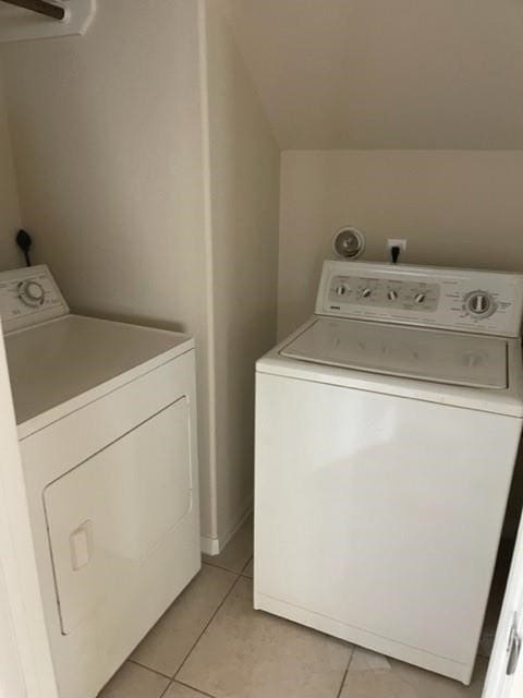 laundry area with separate washer and dryer and light tile patterned floors