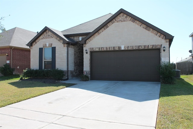 view of front of home featuring a front yard, a garage, and central AC unit