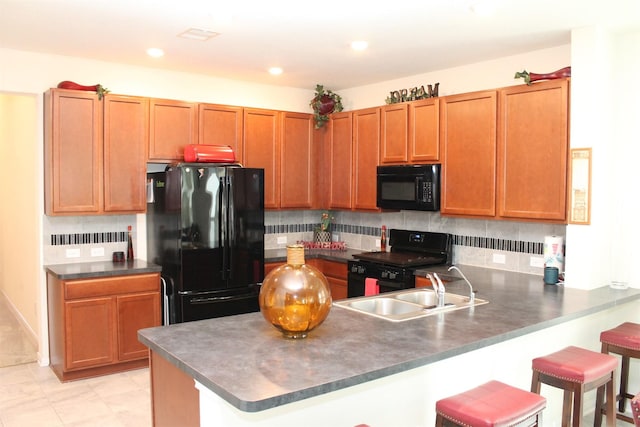 kitchen with black appliances, tasteful backsplash, sink, and kitchen peninsula