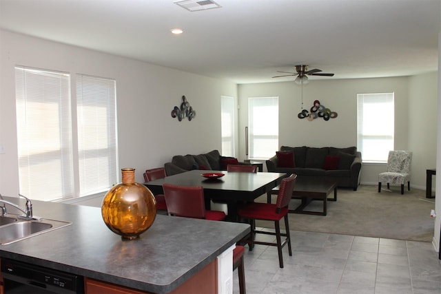 carpeted dining area with ceiling fan and sink