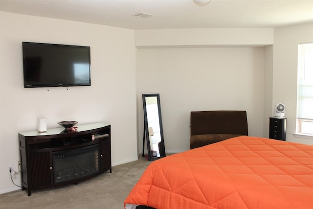 bedroom featuring light carpet and multiple windows