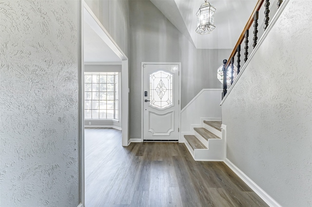 entryway with an inviting chandelier and dark hardwood / wood-style flooring