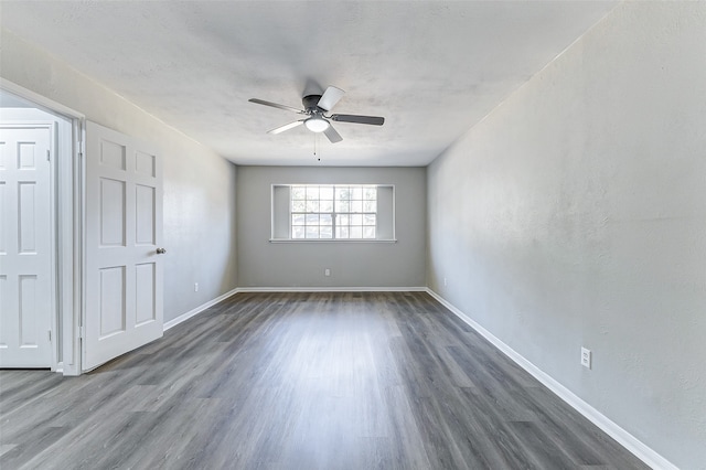 unfurnished room featuring dark wood-type flooring and ceiling fan