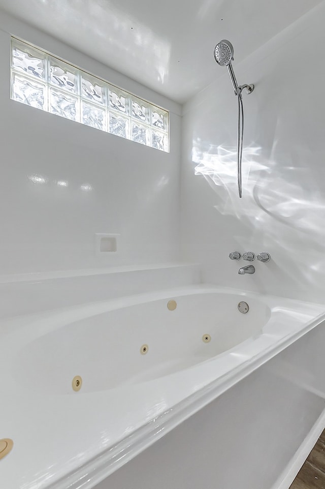 bathroom with hardwood / wood-style flooring and a washtub