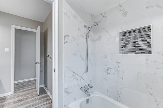 bathroom with tiled shower / bath combo and hardwood / wood-style floors