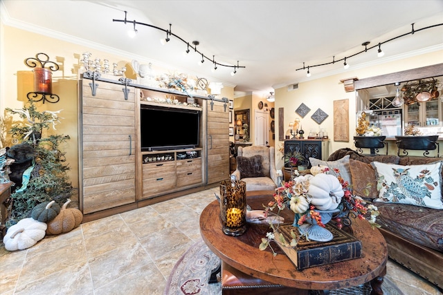 living room featuring rail lighting, crown molding, and a barn door