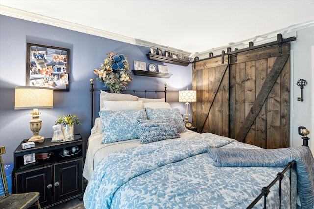 bedroom featuring crown molding and a barn door