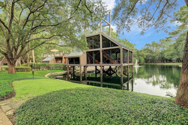 view of dock with a yard and a water view