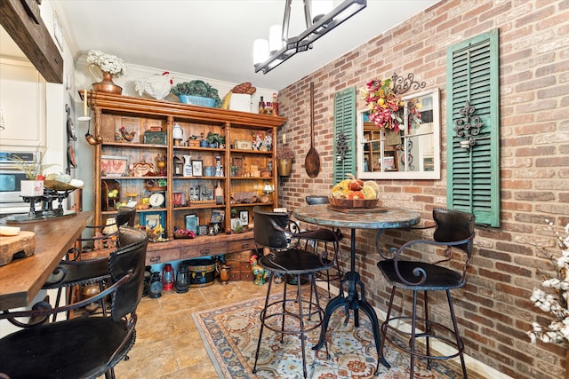 dining space featuring a notable chandelier and brick wall