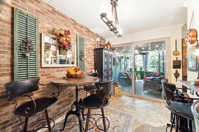 dining area with ornamental molding and brick wall