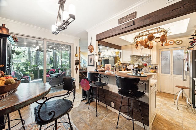 kitchen with tasteful backsplash, kitchen peninsula, a kitchen breakfast bar, white cabinetry, and ornamental molding