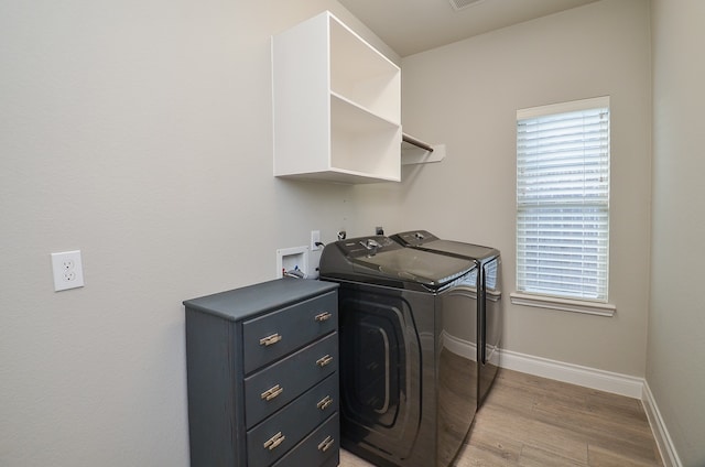 clothes washing area featuring light hardwood / wood-style flooring and washer and clothes dryer