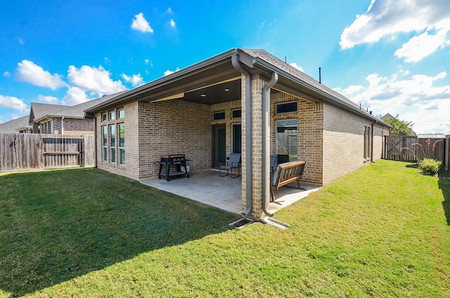 back of property with a patio area and a lawn