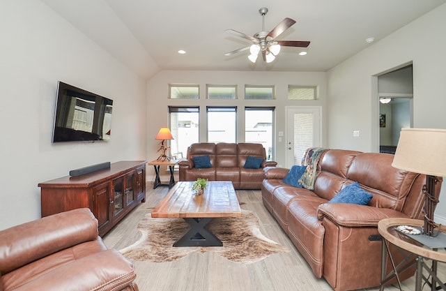 living room featuring light hardwood / wood-style floors, lofted ceiling, and ceiling fan