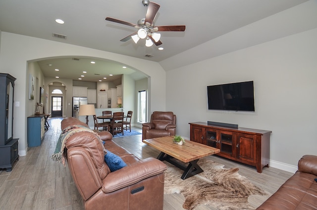 living room featuring vaulted ceiling, light wood-type flooring, and ceiling fan