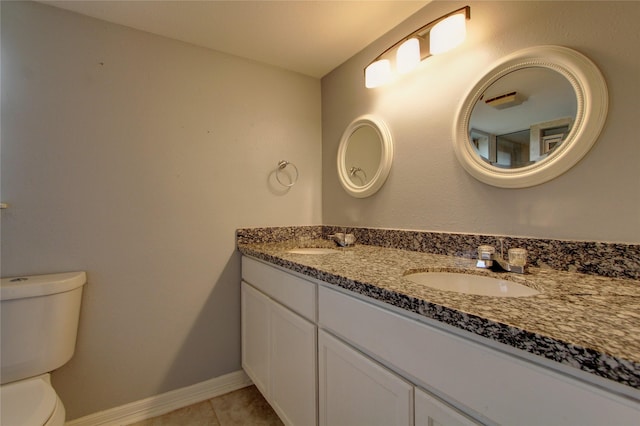 bathroom featuring tile patterned flooring, toilet, baseboards, and a sink