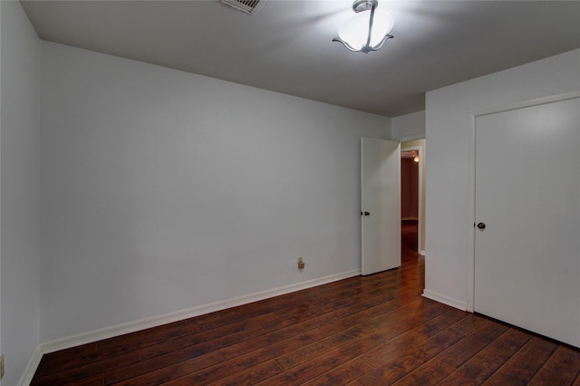 unfurnished bedroom with visible vents, baseboards, and dark wood-style flooring