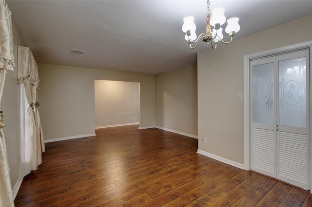 spare room with baseboards, visible vents, and wood-type flooring