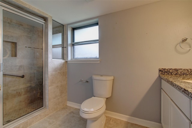 bathroom with vanity, baseboards, tile patterned flooring, a shower stall, and toilet