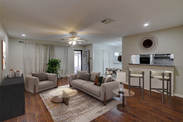 living room with ceiling fan, dark hardwood / wood-style floors, and sink