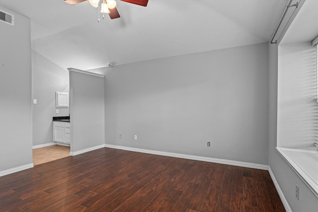 interior space with dark hardwood / wood-style floors, vaulted ceiling, and ceiling fan