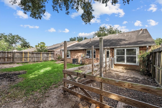 back of property with a lawn and central AC unit