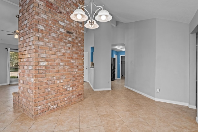 tiled spare room with ceiling fan with notable chandelier