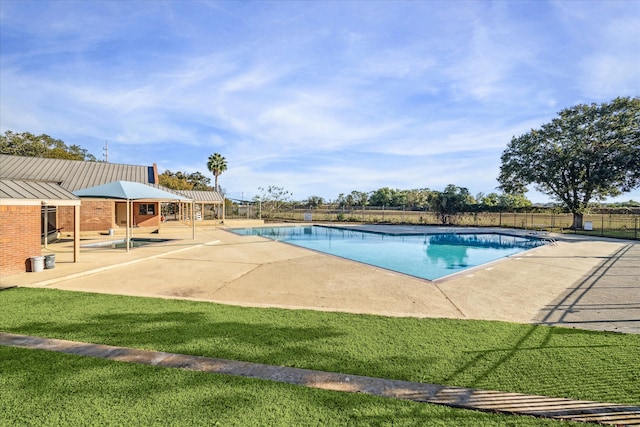 view of swimming pool featuring a lawn and a patio area