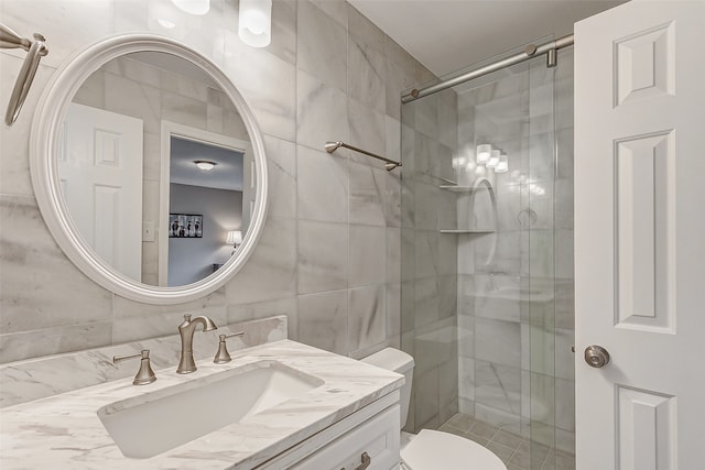 bathroom featuring tile walls, vanity, toilet, and walk in shower