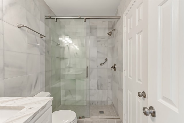 bathroom with toilet, an enclosed shower, and vanity