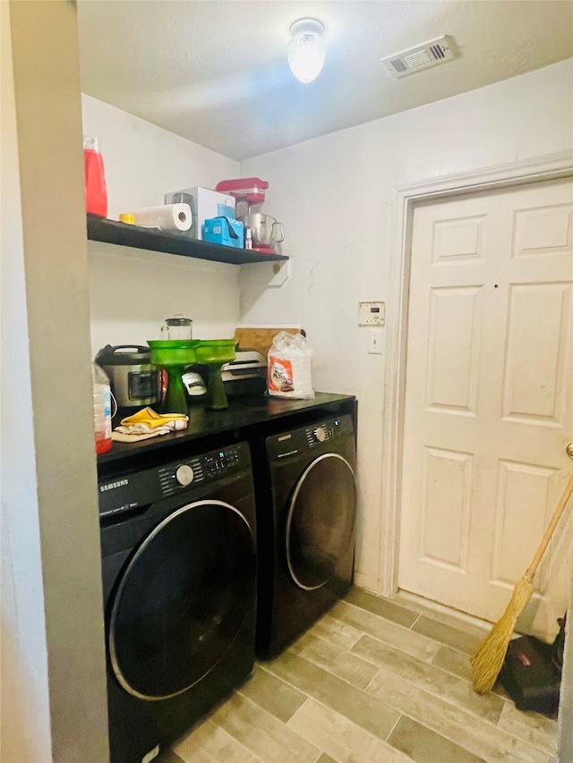 laundry area featuring independent washer and dryer and light wood-type flooring