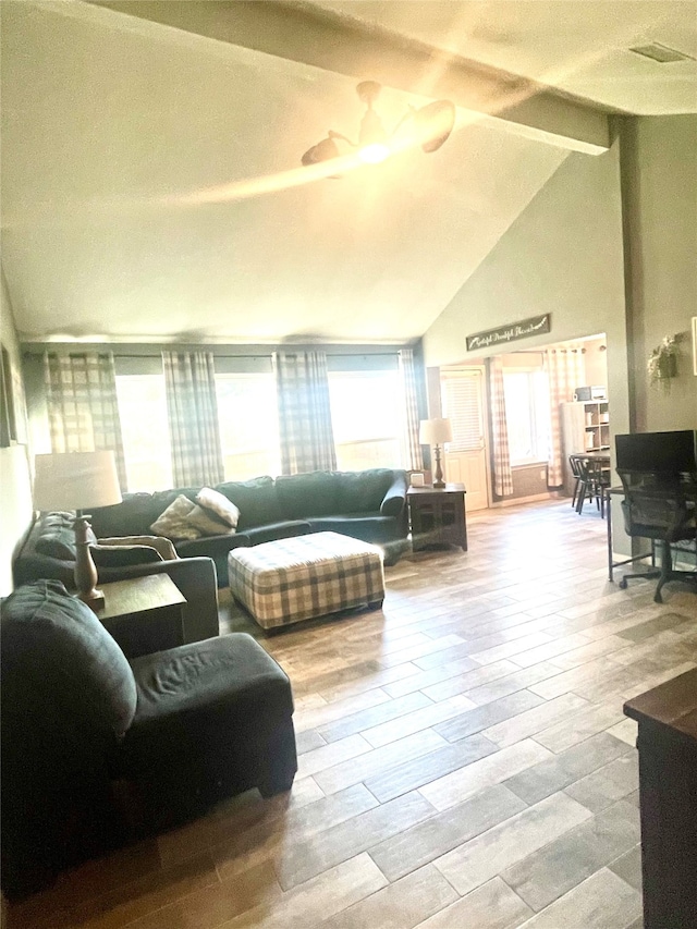 living room with a wealth of natural light, beam ceiling, high vaulted ceiling, and light wood-type flooring