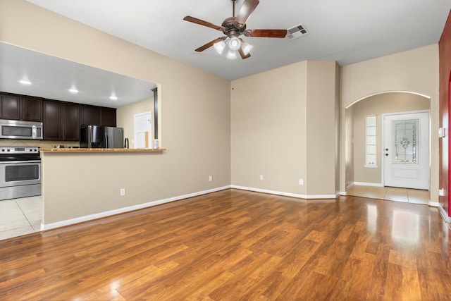 unfurnished living room featuring ceiling fan and light hardwood / wood-style floors