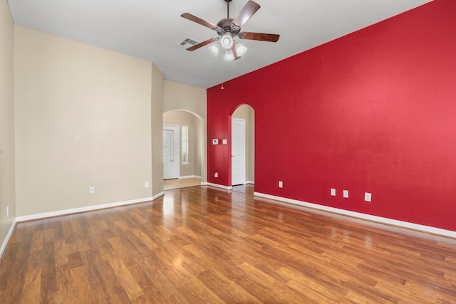 empty room featuring a high ceiling, hardwood / wood-style flooring, and ceiling fan